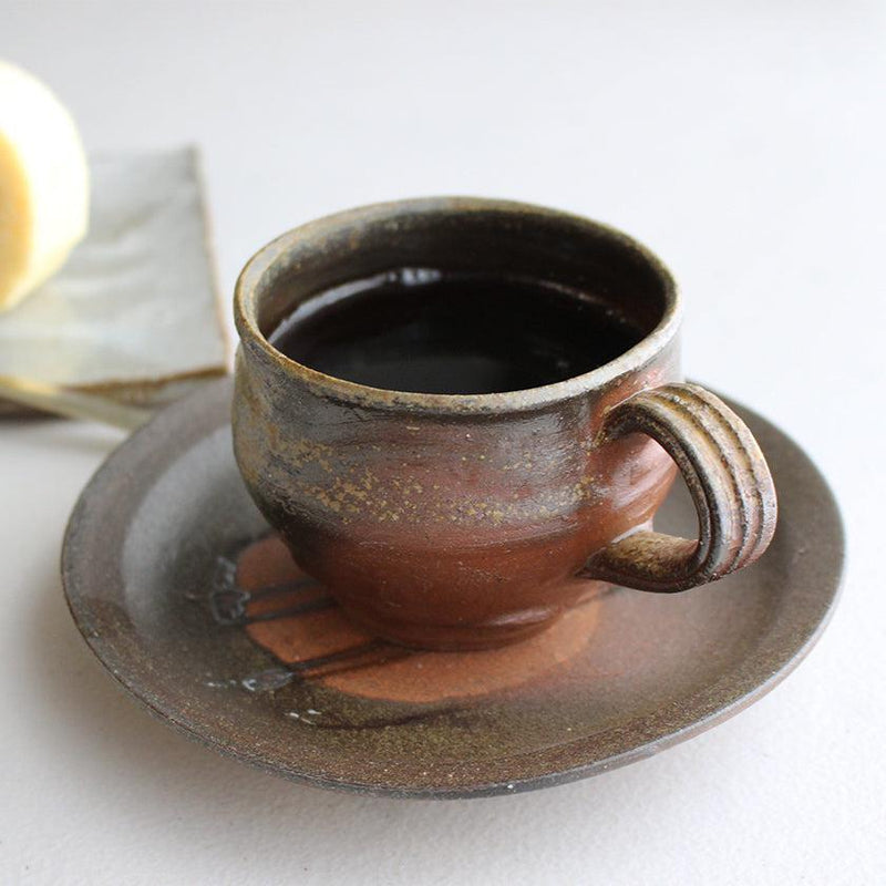 コーヒーを注いだ備前焼コーヒーカップ＆ソーサーのセット、土味ある焦げ茶の釉調が印象的｜備前・恒枝直豆